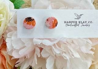 Handcrafted floral stud earrings with pink and orange pattern displayed on Harper Klay Co. jewelry card with flowers.