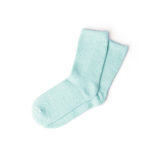 Pair of soft, fuzzy spa socks in light mint green color on white background