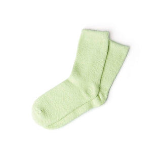 Pair of soft, fuzzy spa socks in light green color on white background