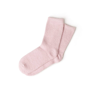 Pair of soft pink fuzzy spa socks on white background