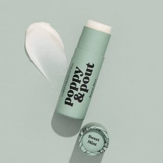 Poppy & Pout Sweet Mint lip balm tube with white product smear on sage green background