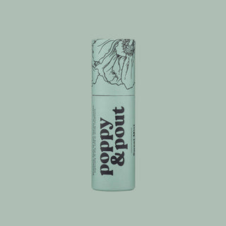 Light green cylindrical lip balm tube with floral line drawing and black text branding.