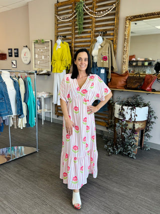 Woman modeling TCEC Sweet Petals Maxi Dress with floral print in boutique setting