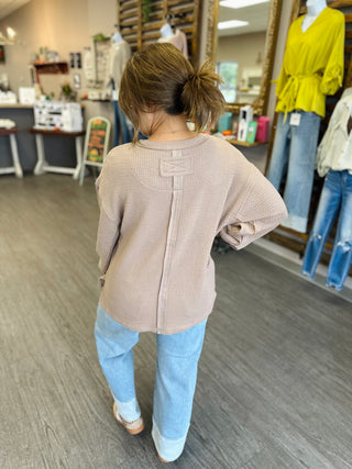 Back view of a relaxed-fit textured waffle knit top with center seam detail.