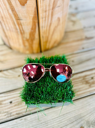 Stayson aviator sunglasses with mirrored lenses resting on artificial grass against wooden deck background