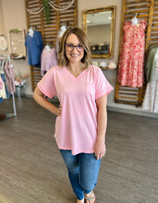 Woman wearing relaxed pink v-neck pocket tee with short sleeves in clothing boutique store