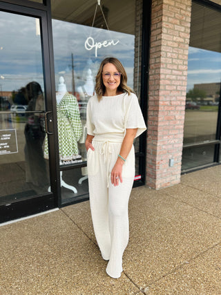 Woman wearing Allie Rose Gathered Grace Pants with matching top outside a boutique storefront.