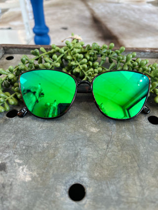Stayson Mia sunglasses with mirrored lenses displayed on wooden surface with succulent plants