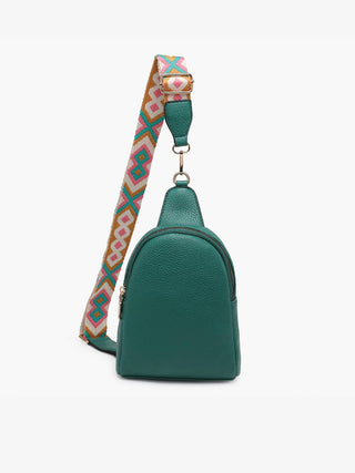 Green leather sling bag with colorful geometric patterned strap and gold hardware