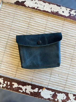Black leather Wendy Wallet with snap closure on bamboo mat with weathered wood frame