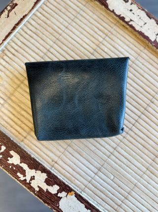 Black leather Wendy Wallet by Kemp's Krafts displayed on rustic wooden surface with bamboo mat.