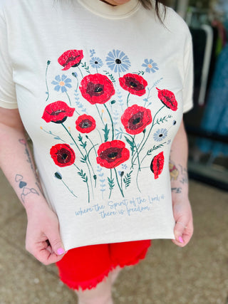 Woman wearing cream t-shirt with red poppies and blue flowers design and inspirational text