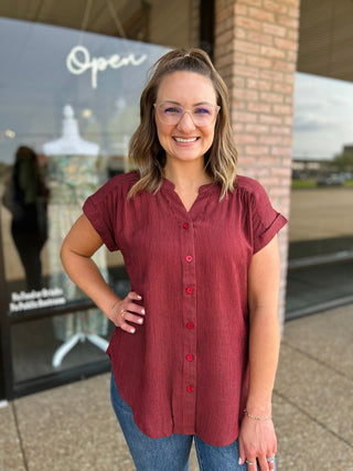Woman smiling outside boutique wearing Blu Pepper Timeless Stripe Blouse with button-front detail.