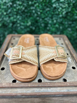 TOMS sandals with woven buckle straps and cork footbeds displayed on wooden crate outdoors