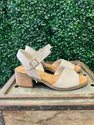 TOMS Eloise shimmer sandals with ankle strap and block heel displayed on wooden crate outdoors