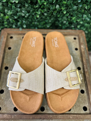 TOMS Marin sandals with adjustable buckle straps and cork footbed on wooden surface