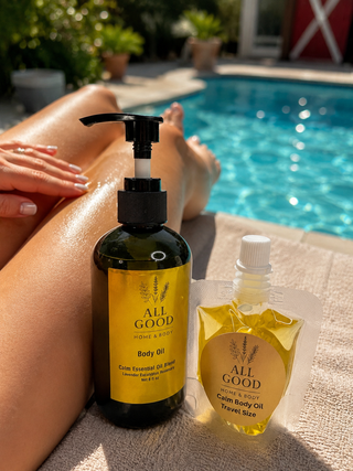 All Good Home & Body Calm Body Oil travel size pouch beside full-size bottle near pool.