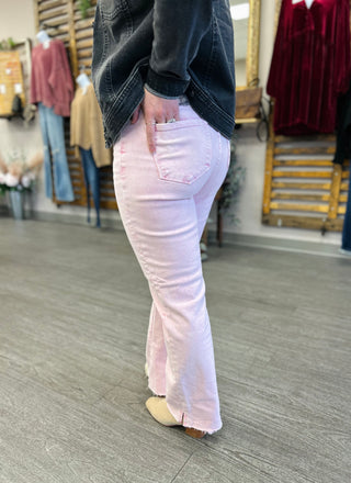 Woman wearing pink straight leg jeans with dark denim jacket in clothing store setting