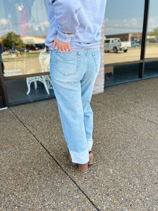 Back view of wide leg jeans with cuffed hem, worn with heeled mules and a sweatshirt.
