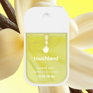 Touchland Power Mist hydrating hand sanitizer in clear bottle with yellow liquid against floral background