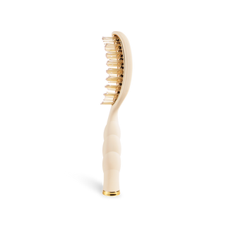 TELETIES vented hair brush with gold metal bristles and ergonomic ribbed handle, side view.