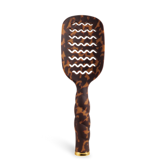 TELETIES vented hair brush with tortoiseshell pattern, wavy handle, and gold-tipped base.