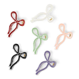 Six colorful bow-shaped hair clips in various translucent colors arranged on white background