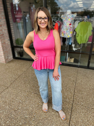 Woman wearing Hidden Jeans vintage high rise wide straight jeans with cuff and pink top outside boutique