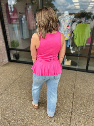 Woman wearing vintage high rise wide straight jeans with cuff and pink top, viewed from behind.