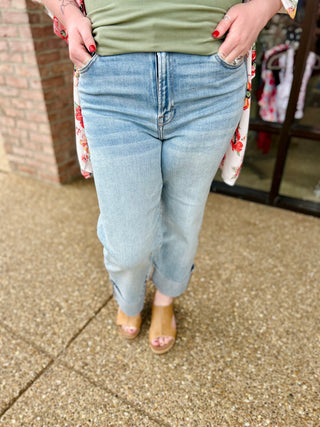 Woman wearing light blue high-rise wide leg jeans with cuffed hem and platform sandals