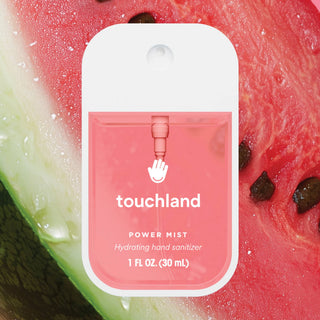Touchland Power Mist hydrating hand sanitizer in clear spray bottle against fresh watermelon background