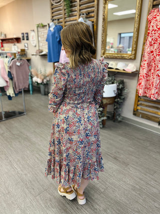 Woman wearing Carol Christian wildflower ruffle dress with long sleeves and tiered hem in clothing store