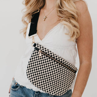 Woman wearing Pretty Simple woven checkered bum bag crossbody style with white lace top and jeans.