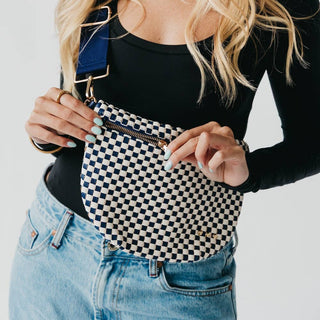 Woman wearing checkered woven bum bag crossbody style with black top and jeans